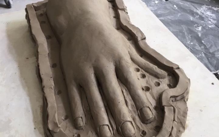 On display is an oversized hand made of clay