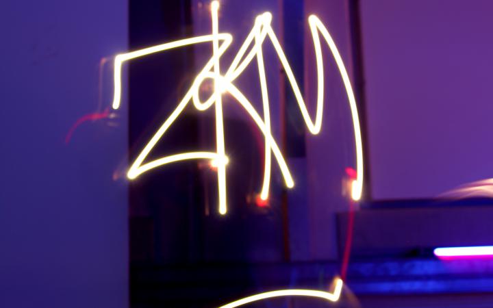 The word ZKM can be seen in luminous lettering made of light sticks at an event of the cultural academy.