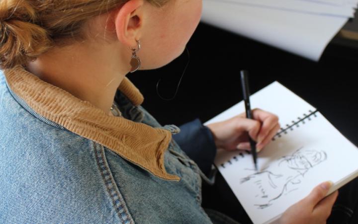 Foto einer jungen Frau beim Zeichnen