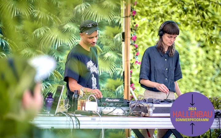 Ein DJ und eine DJane stehen draußen an einem Mischpult, im Hintergrund viel Grün.