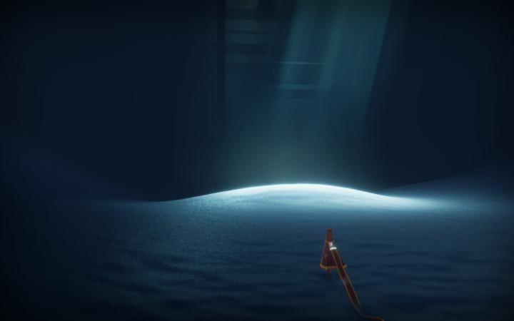 Die Spielfigur befindet sich in einer dunklen Höhle. In der Mitte der Hähle fällt helles Licht auf den bläulichen Sand