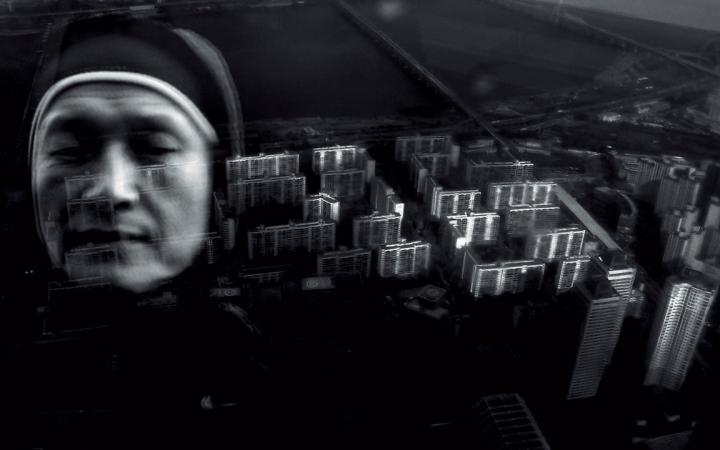Die Schwarzweiß-Collage zeigt eine Nonne vor einer Vogelperspektive auf Wolkenkratzer. 