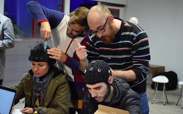 Das Bild zeigt Workshopteilnehmende beim Anbringen von Kopfsensoren.