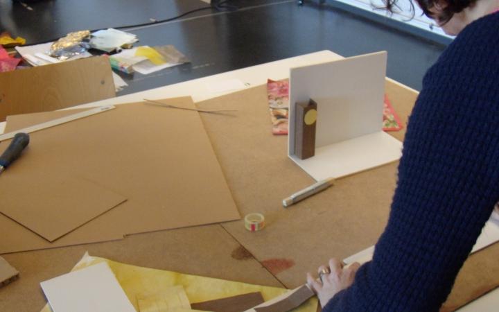A woman is working on a miniature stage scenery