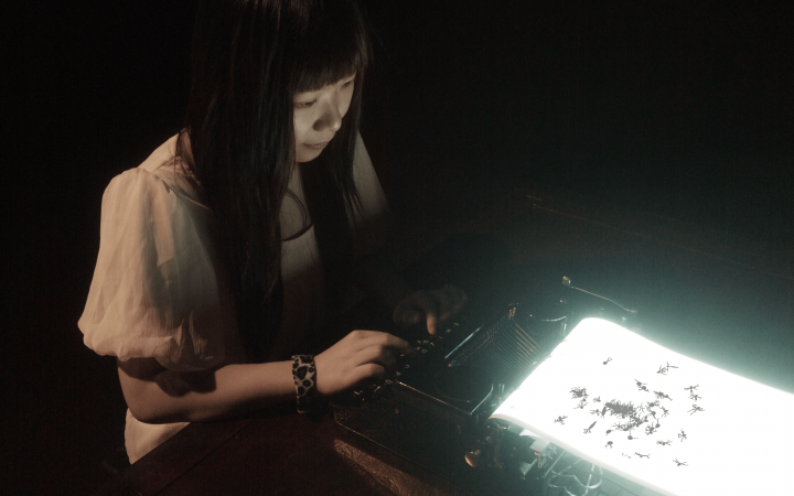 A woman is typing on a glowing typewriter