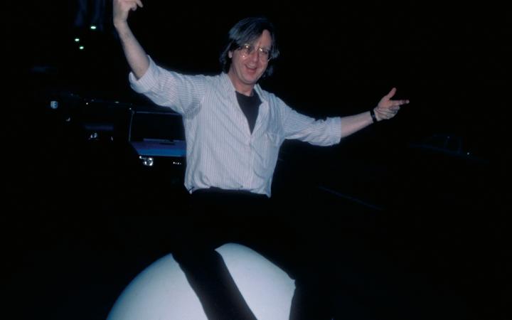 Fotografie von Gerhard Johann Lischka, auf einer großen weißen Kugel sitzend