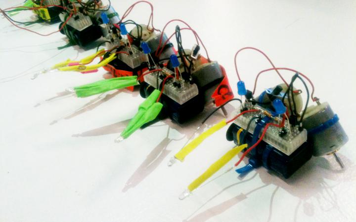 Five little T2-R2-robots out of electronic parts that are held together by ziptie