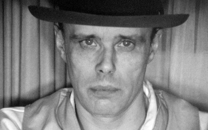 A black and white portrait of the artist Joseph Beuys.
