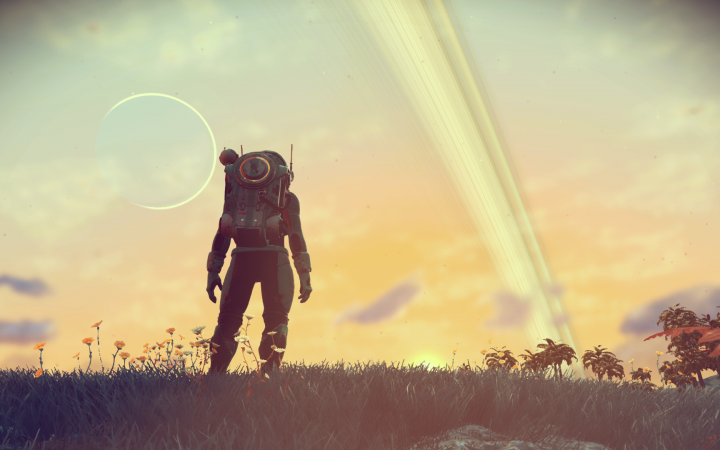 An atronaut stands on a meadow against a sky backdrop