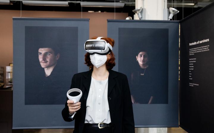 Zu sehen ist die Ko-Kuratorin Teresa Retzer, die mit VR-Brille im Ausstelungsraum steht