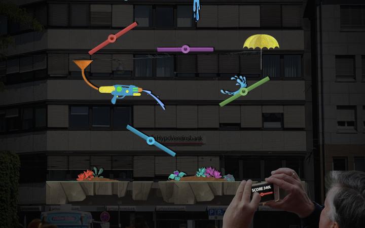 Eine riesige Projektion zeigt einzelne fabrige Elemente verteilt: ein langer Wasserhahn, eine Wasserpistole mit Trichter, ein Regenschirm.