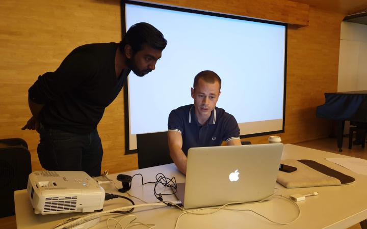 Zu sehen sind zwei Männer vor einem Laptop im Rahmen eines Workshops des ZKM im Goethe-Institut in Mumbai.