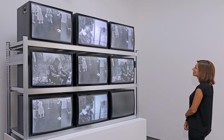 Visitor in front of an installation consisting of nine TV screens