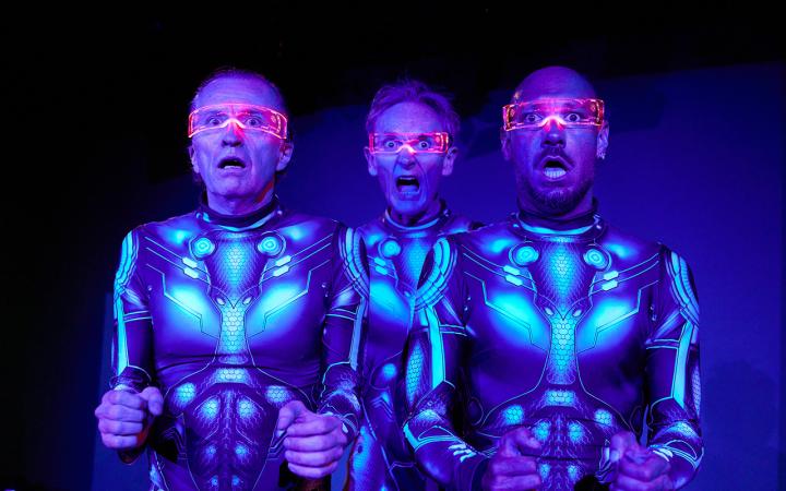 Drei Personen in futuristischen Rüstungen und mit rot-transparenter Brille