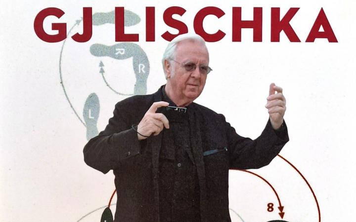 Zu sehen ist ein Mann, GJ Lischka, er ist in einer tanzenden Bewegung festgehalten und die Schrift TANZ DIE MEDIEN zieht sich über das Bild