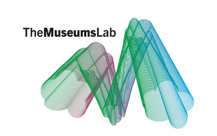 Ein grün-blaues geoemtrisches Konstrukt vor einem weißen Hintergrund. Links oben der Schriftzug »The MuseumsLab« in Schwarz.