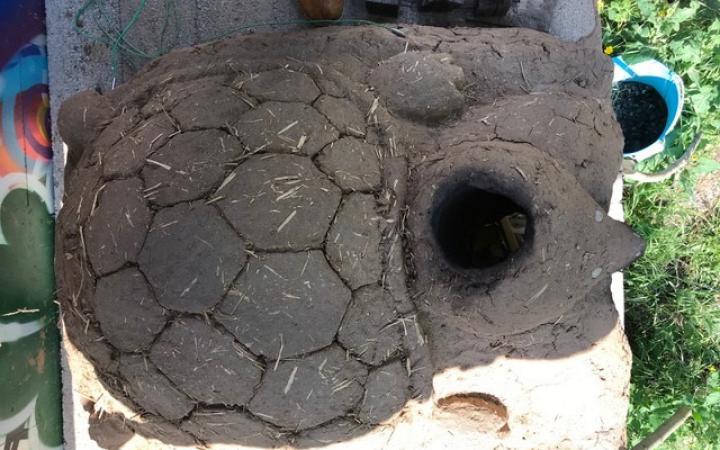 A clay oven with a turtle made of clay on top.