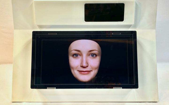 A small screen shows a female face against a blue background.