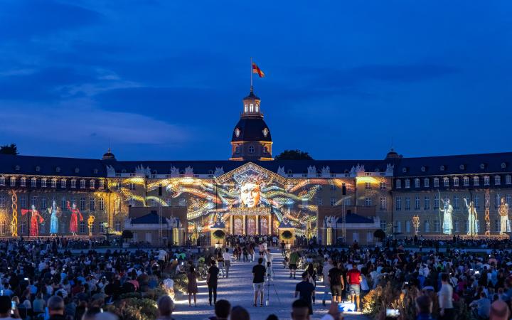 In the foreground you can see the audience that was present at the opening of the Schlosslichtspiele. Projected on the castle you can see a face reminiscent of Medusa, because the head has snakes instead of hair.