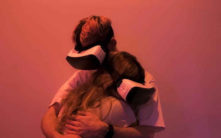Two people with VR glasses hug each other 