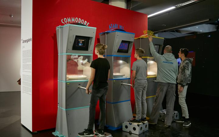 Three of out of six gaming Stations of the Artwork »Ahnengalerie« with people playing with them.
