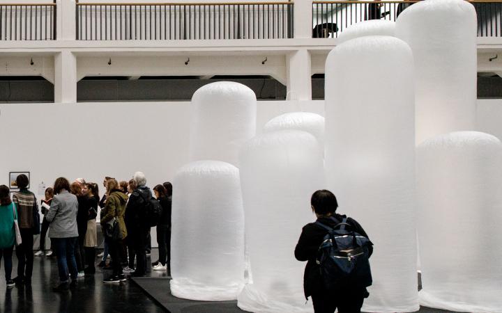 A person stands in front of inflated plastic tubes.