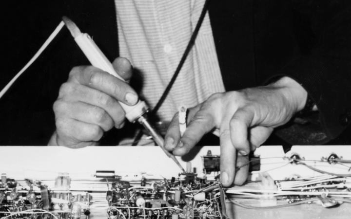 Man sieht die Hände von Walter Giers am elektronischen Pult. In der einen Hand hält er eine Zigarette. 