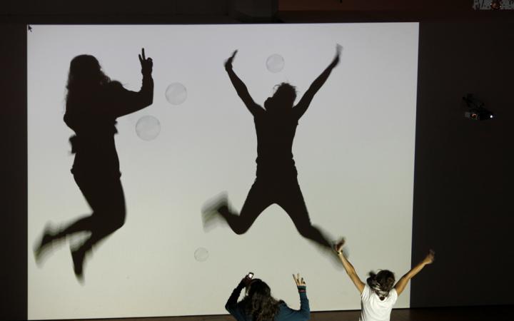 Shadows of children who interact with animated bubbles