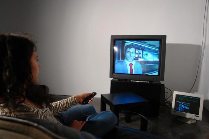 A woman sitting in front of a television with a remote control