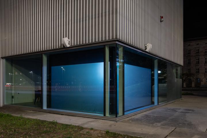 You can see a glass facade, the corner of which is illuminated blue