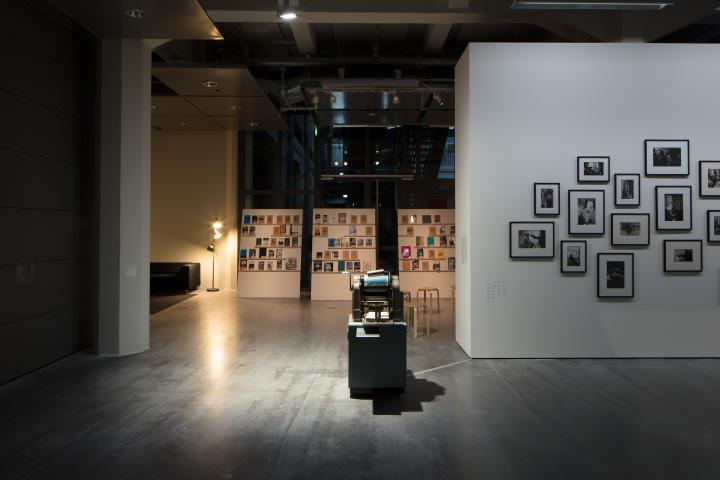 Blick in die Ausstellung »Beat Generation«: Zu sehen sind im Hintergrund einige Bücher, im Zentrum eine alte Druckmaschine und am rechten Rand mehrere Schwarz-Weiß-Fotografien