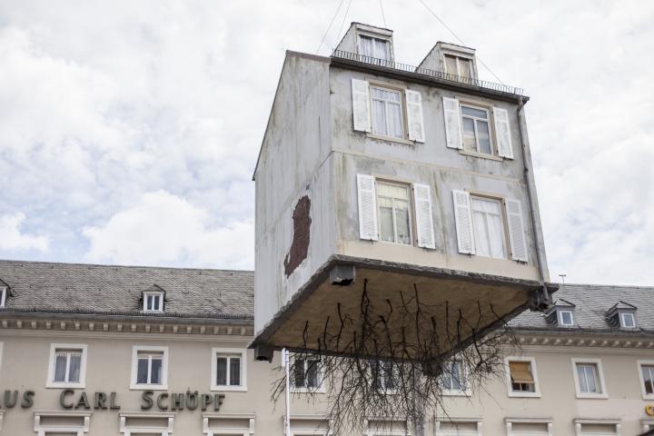 A house hangs on a crane
