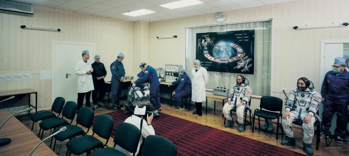 A conference room. There are several astronauts and doctors.