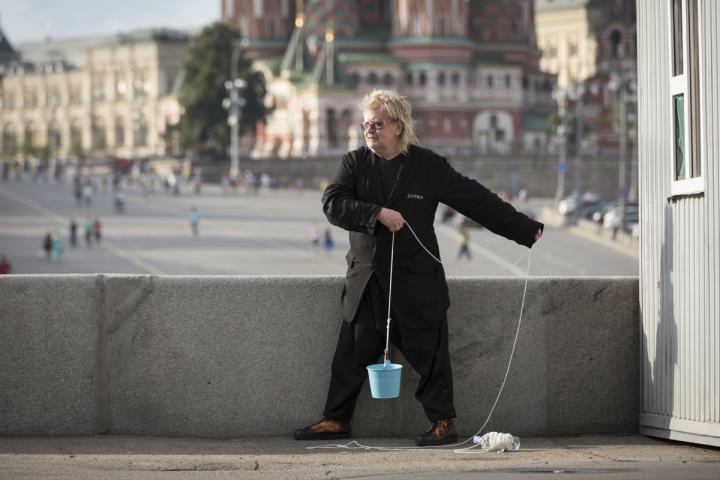 A man holding a cord with a blue bucket