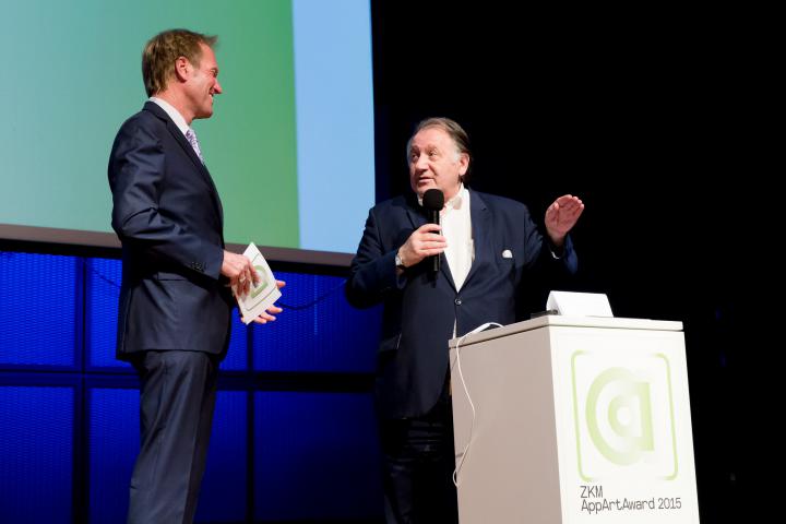 Two men talking to each other on stage