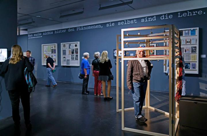 Menschen stehen im Ausstellungsraum und betrachten die Werke