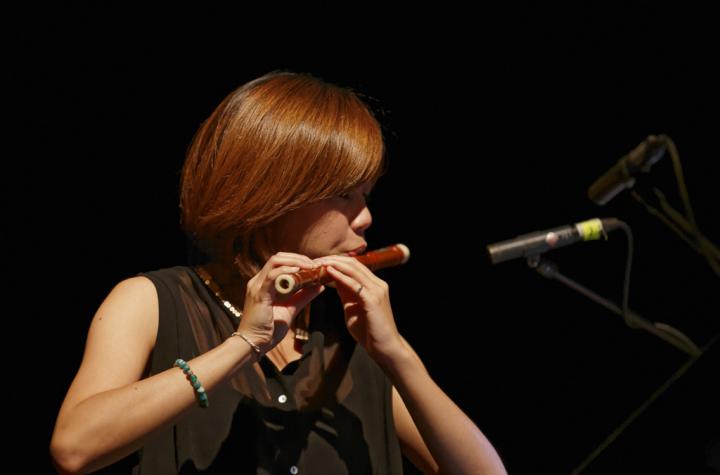 A woman playing a kind of transverse flute