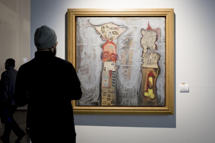 Ein Mann betrachtet ein abstraktes Gemälde