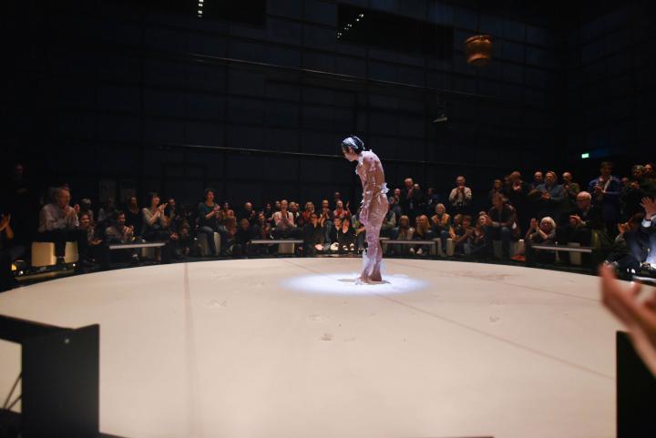 A male person bows and is wrapped in a kind of plastic film