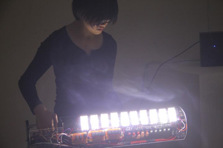 A woman on a self-built, illuminating instrument