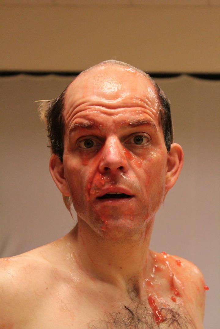 Das Foto zeigt ein Portrait von Daniel Schröteler. Er trägt kein Hemd und hat roten Glibber in Gesicht und auf der Brust. 