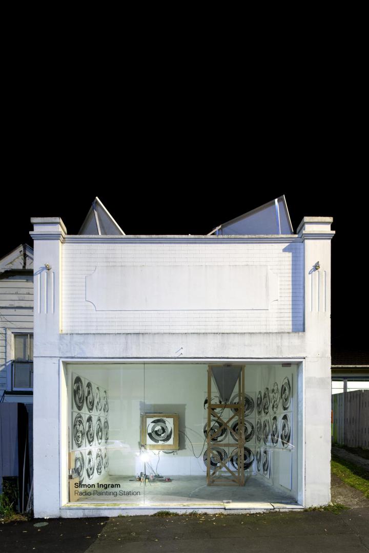 Das Bild zeigt ein weißes, kastenförmiges Gebäude, in der sich die »Radio Painting Station« von Simon Ingram befindet