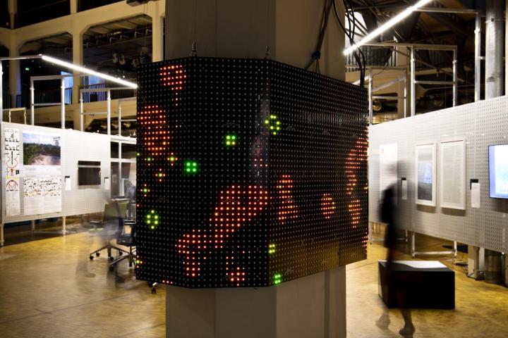 Abbildung des Werkes »Game of Life«, Lichtpunkte auf einem um die Säule verlaufenden Screen