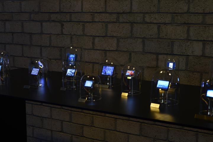 The photo shows a dark table with several glass bells with integrated displays are exposed.