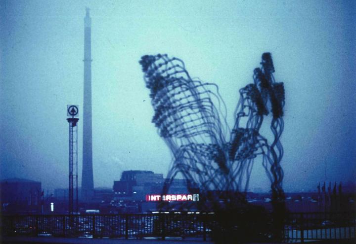 »Imaginäre Architekturen« von Otto Beckmann. Zu sehen ist eine trübe Skyline. Zwei große, figürliche Architekturen bilden das Hauptmerkmal. 