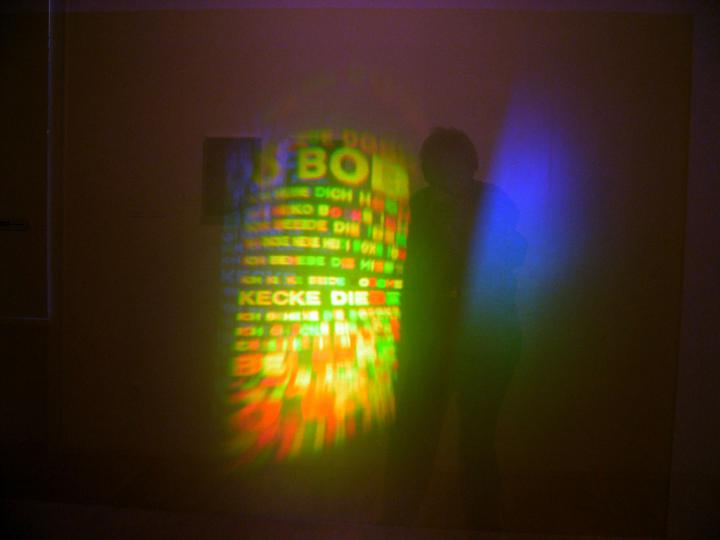 The picture shows a green-yellow light installation with letters. 