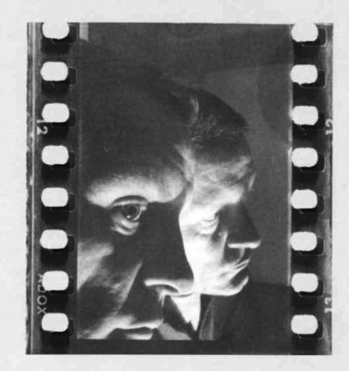 Die Schwarz-Weiß-Fotographie zeigt ein Portrait Helmut Heißenbüttels, der sich seitlich in einem Spiegel spiegelt. 