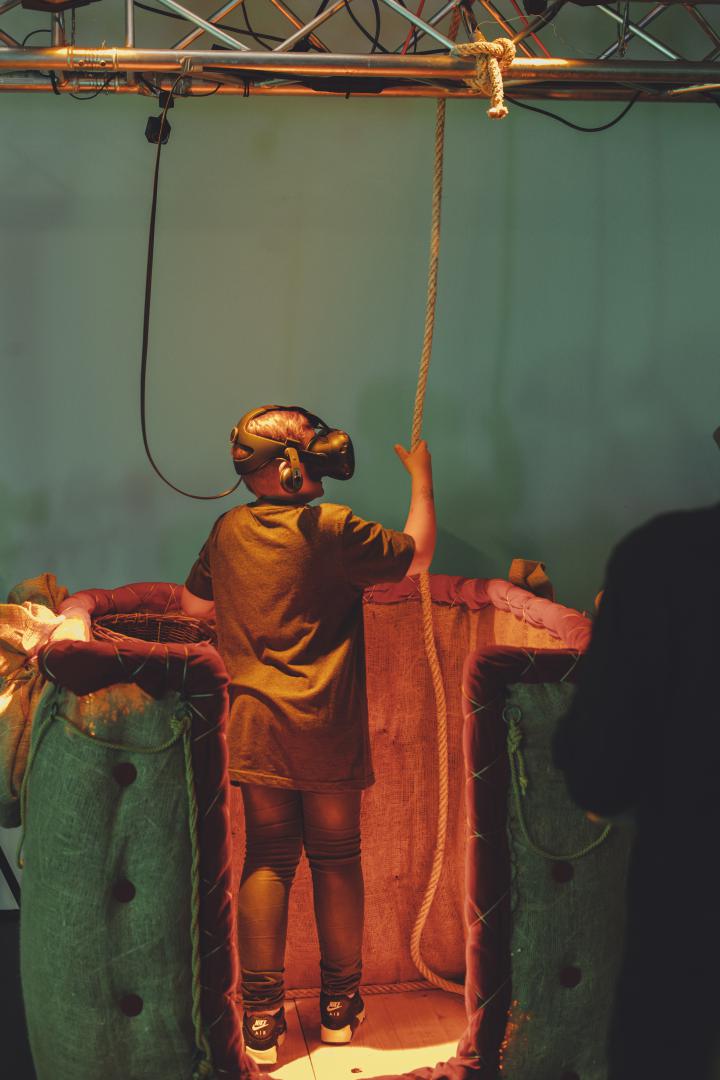 A children wearing VR glasses stands in a hot-air balloon 