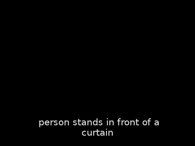 The screenshot shows a white text on a black background. The text says: "person stands in front of a curtain".