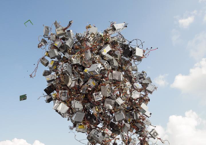 The picture shows an animated pile of electronic devices rising into the sky.
